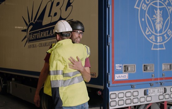 Fredric and Lars Kristen hug in front of the lorry six months after the accident.