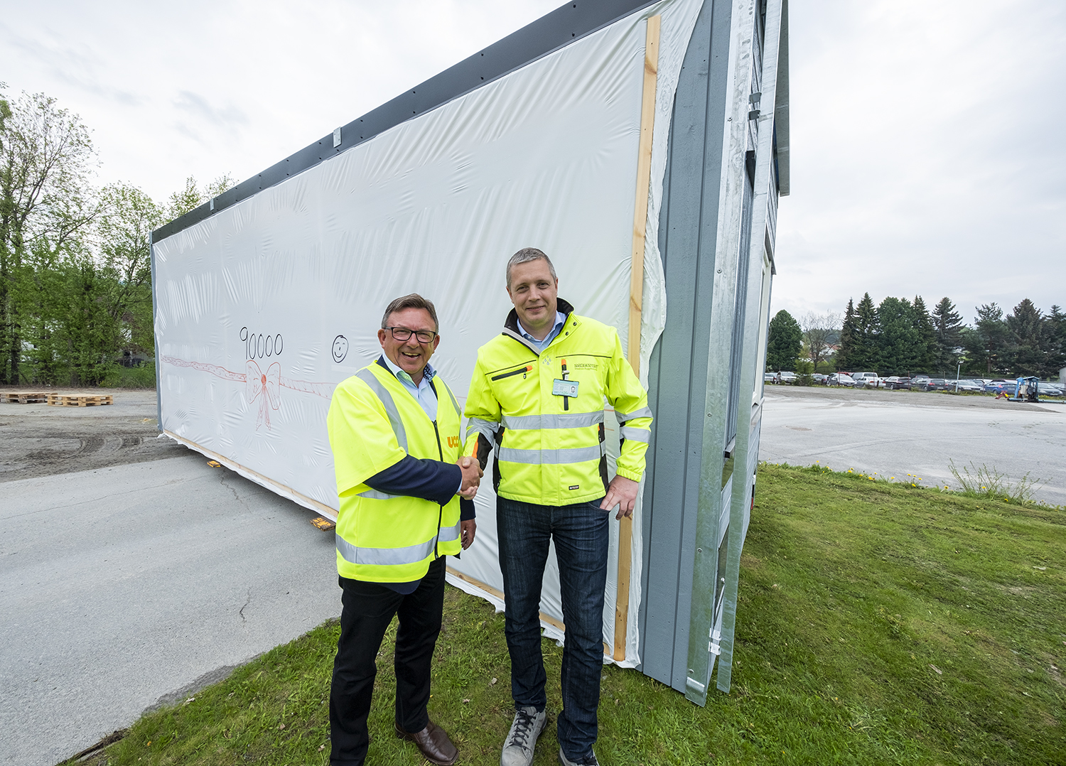 Jostein Stormo, adm. dir i Utleiecompagniet og Lars Brede Aandstad, daglig leder i Moelven Byggmodul, foran modul nr. 90 000